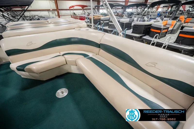 Slide: The Image of 2000 Bennington 227L boat interior with beige and green seating at Reeder-Trausch Marine. - 29