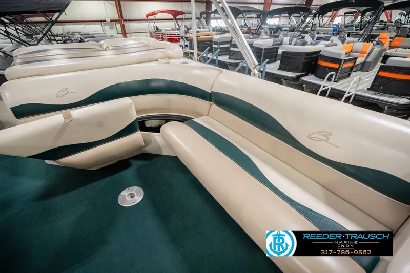 Slide: The Image of Bennington 227L 2000 model boat interior with beige and green seating in showroom. - 30