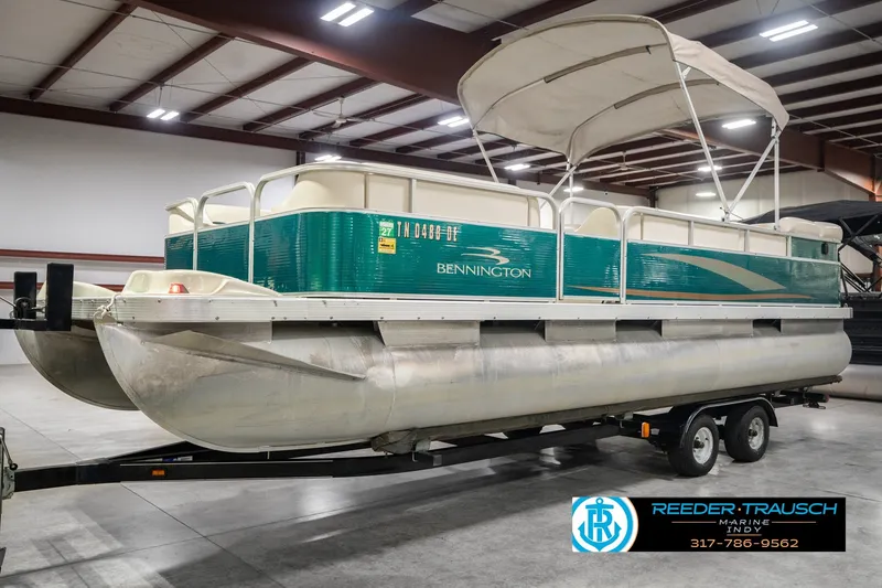 Slide: The Image of 2000 Bennington 227L pontoon boat on trailer in indoor storage facility. - 2