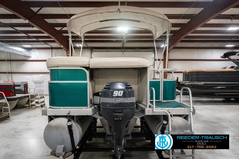 Slide: The Image of Bennington 227L pontoon boat, 2000 model, with canopy and outboard motor in a showroom. - 9