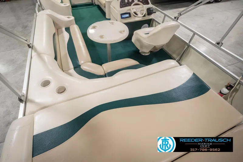 Slide: The Image of Bennington 227L 2000 pontoon boat interior with beige seating and green carpet. - 17