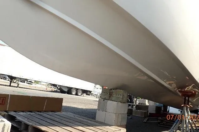 Slide: The Image of 2023 Cape Horn 34XS boat hull on blocks, outdoor setting. - 23