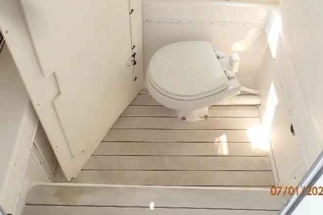 Slide: The Image of 2023 Cape Horn 34XS boat bathroom with white toilet and wooden flooring. - 48