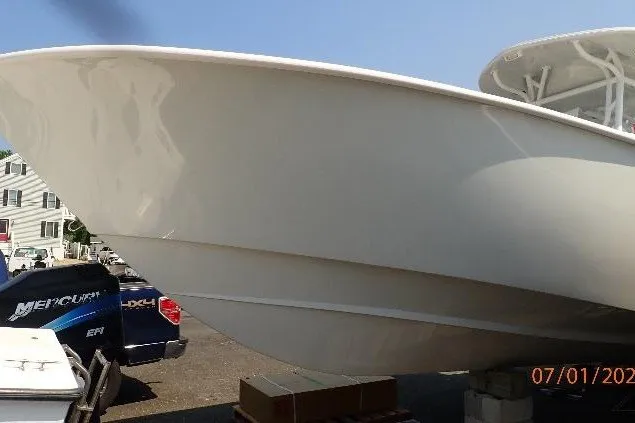 Slide: The Image of 2023 Cape Horn 34XS boat hull in a parking area, with vehicles nearby. - 21