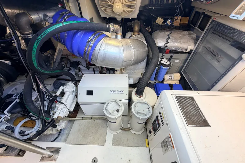 Slide: The Image of Engine room of a 2014 Azimut 64 yacht, featuring mechanical equipment and piping. - 51
