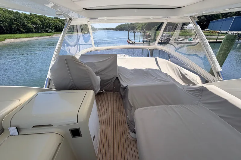Slide: The Image of 2014 Azimut 64 yacht deck with covered seating, overlooking serene waterway. - 39