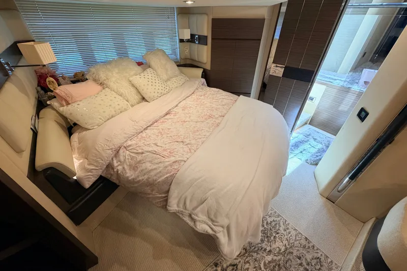 Slide: The Image of Luxurious bedroom interior of a 2014 Azimut 64 yacht, featuring plush bedding and elegant decor. - 33