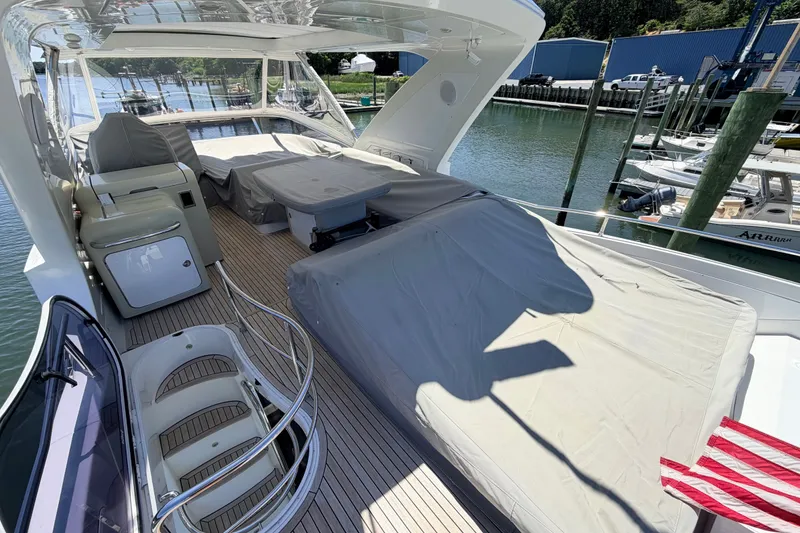 Slide: The Image of Luxurious 2014 Azimut 64 yacht deck with covered seating and scenic marina view. - 44
