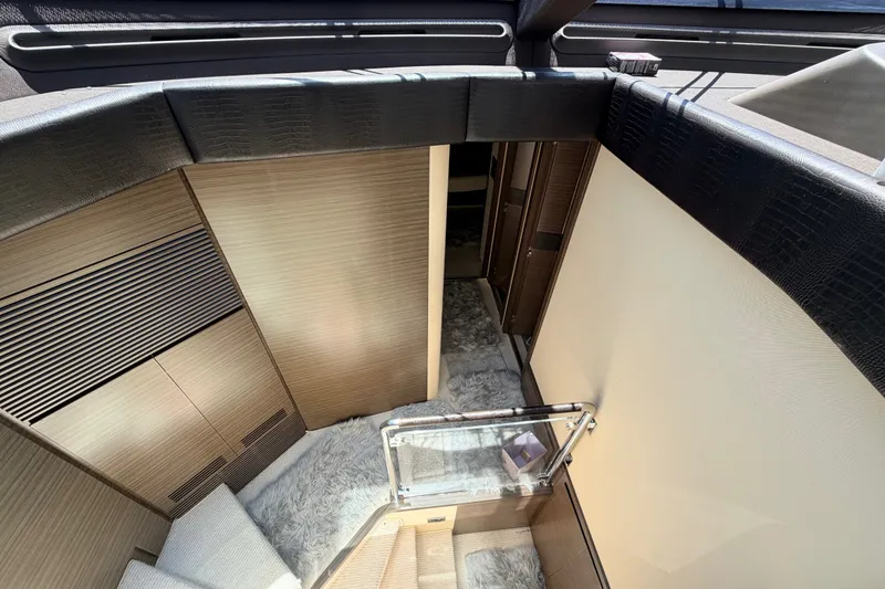 Slide: The Image of Interior view of 2014 Azimut 64 yacht, featuring modern wood paneling and plush carpeting. - 21