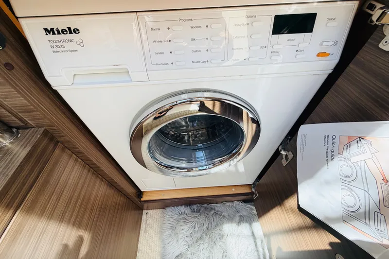 Slide: The Image of Miele Touchtronic W3033 washer inside 2014 Azimut 64 yacht, with wooden flooring and manual. - 31