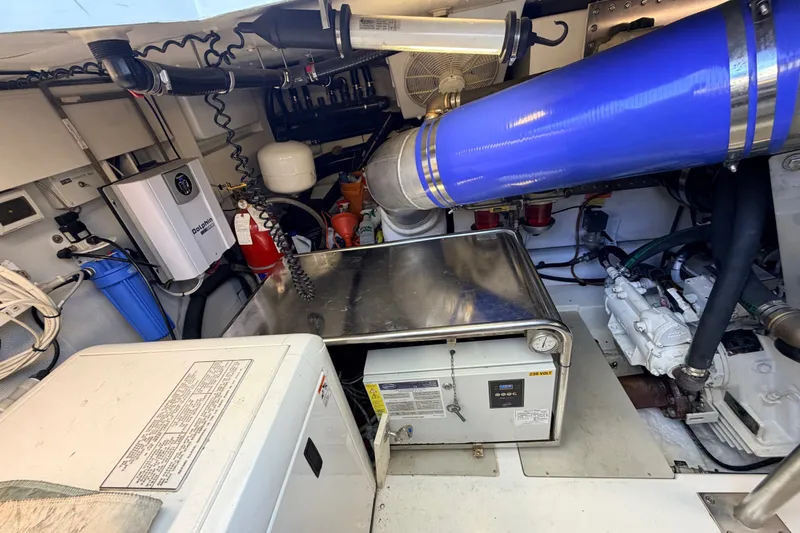 Slide: The Image of Engine room of a 2014 Azimut 64 yacht, featuring mechanical equipment and piping. - 50