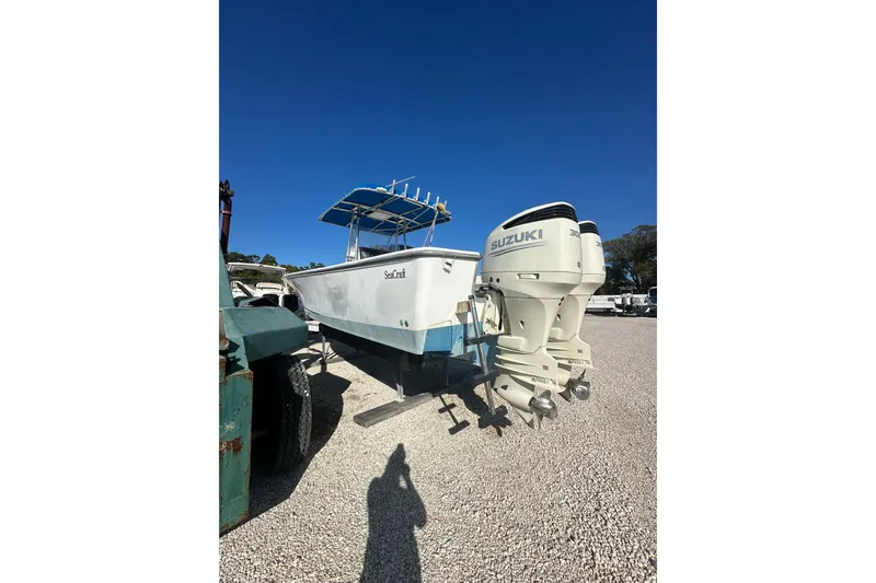 Slide: The Image of 2000 SeaCraft SC 32 Master Angler boat with twin Suzuki outboard motors on gravel. - 1