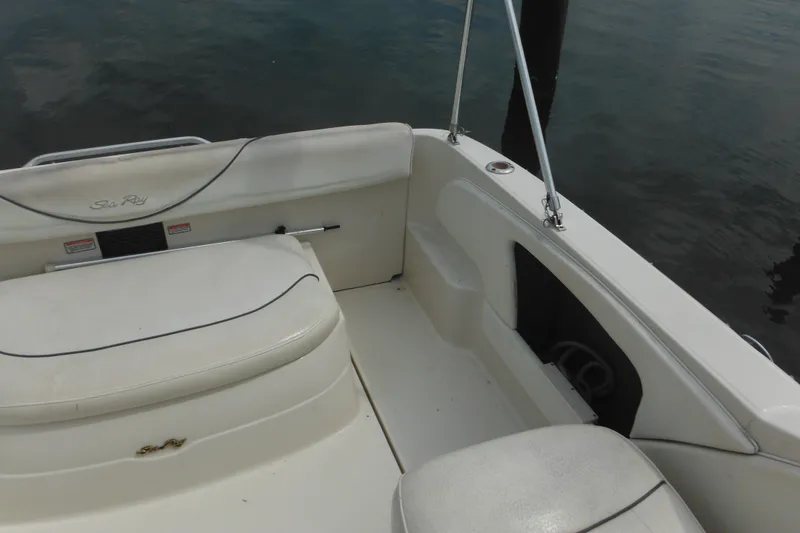 Slide: The Image of 2004 Sea Ray 245 Weekender boat interior with white seating and sleek design. - 17