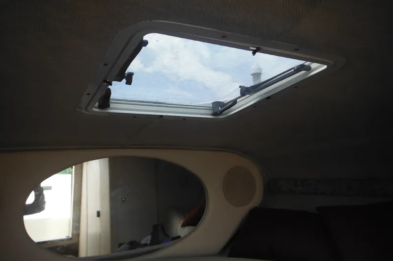 Slide: The Image of Interior cabin view of a 2004 Sea Ray 245 Weekender with a skylight and oval mirror. - 52