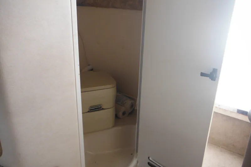 Slide: The Image of 2004 Sea Ray 245 Weekender boat interior with compact bathroom. - 50