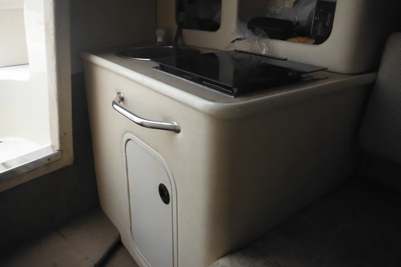 Slide: The Image of 2004 Sea Ray 245 Weekender interior kitchenette with sink and stove. - 41