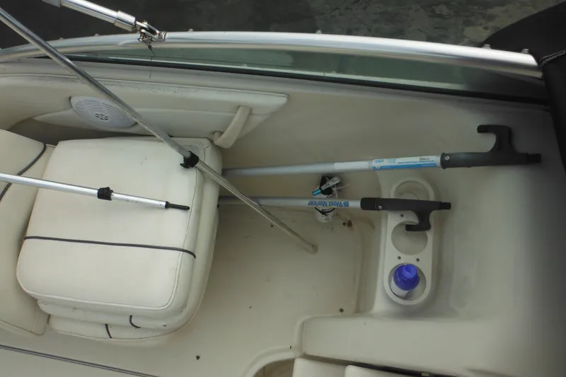 Slide: The Image of Interior of a 2004 Sea Ray 245 Weekender boat with fishing rods and cup holders. - 54