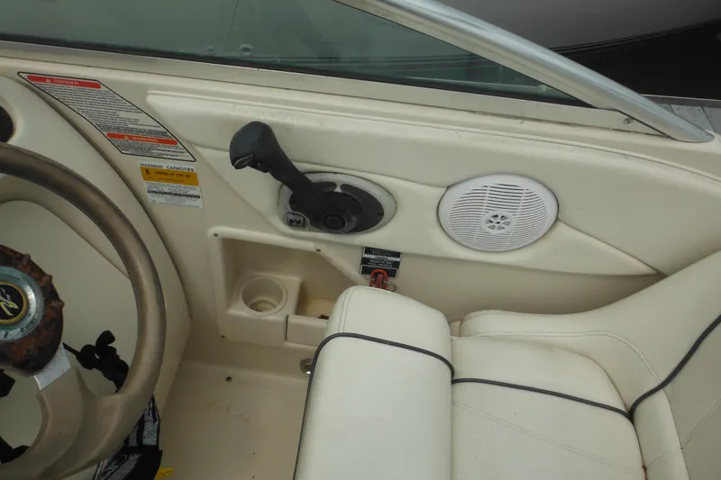 Slide: The Image of Interior of 2004 Sea Ray 245 Weekender boat, featuring steering wheel and control panel. - 28