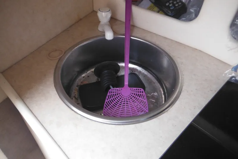 Slide: The Image of Sink area in a 2004 Sea Ray 245 Weekender boat with cleaning tools. - 46
