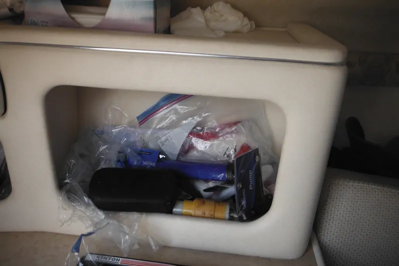 Slide: The Image of Storage compartment in a 2004 Sea Ray 245 Weekender boat, containing various items. - 45