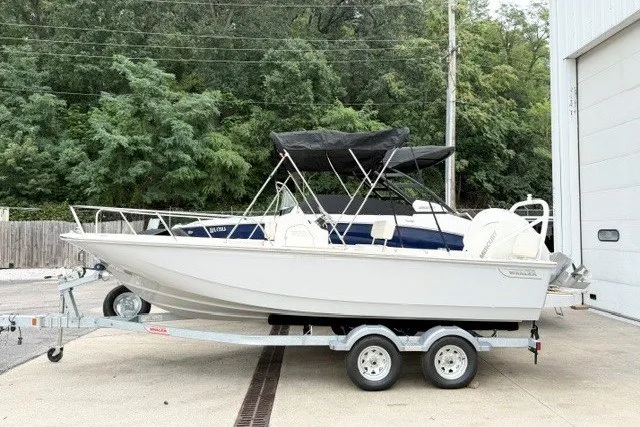 The Image of 2027 Boston Whaler 190 Montauk boat on trailer, parked outdoors near trees. - 0