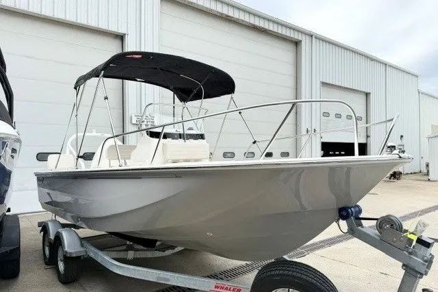 Slide: The Image of 2027 Boston Whaler 190 Montauk boat on trailer, parked outside a warehouse. - 2
