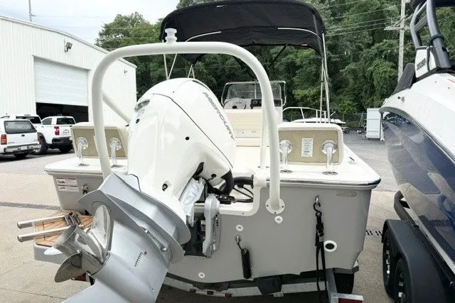 Slide: The Image of 2027 Boston Whaler 190 Montauk boat with outboard motor, parked outdoors. - 3