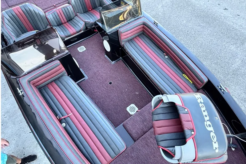 Slide: The Image of 1988 Ranger 375V boat interior with red and gray seating, showcasing spacious design. - 4
