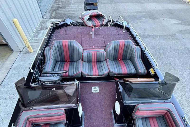 Slide: The Image of 1988 Ranger 375V boat interior with striped seats and maroon carpet. - 7