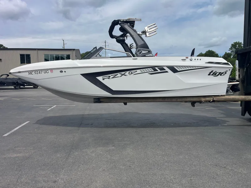 The Image of A white 2018 Tigé 23RZX boat is being transported on a trailer. - 0