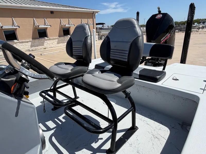 Slide: The Image of Two padded seats on a boat with an outboard motor in the background. - 23
