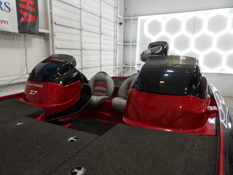 Slide: The Image of A 2010 Nitro Z-7 boat with red and black accents in a garage. - 5