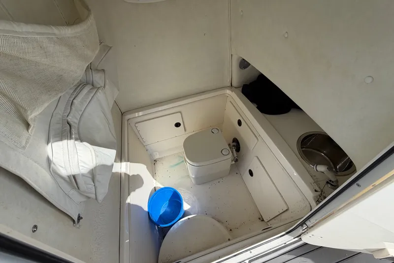 Slide: The Image of Interior of 1999 Boston Whaler 26 Outrage boat with compact toilet and storage. - 32
