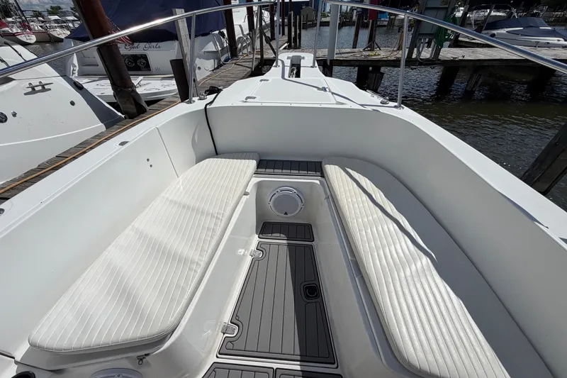 Slide: The Image of 1999 Boston Whaler 26 Outrage boat interior with white seating and dock view. - 37
