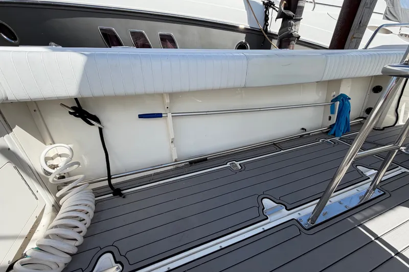 Slide: The Image of 1999 Boston Whaler 26 Outrage boat deck with coiled hose and stainless steel railing. - 18