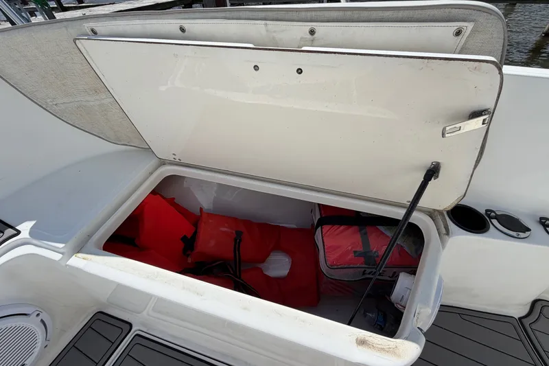 Slide: The Image of Open storage compartment on a 1999 Boston Whaler 26 Outrage, containing life jackets and gear. - 43