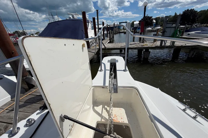 Slide: The Image of 1999 Boston Whaler 26 Outrage boat docked, open anchor compartment, sunny day. - 41