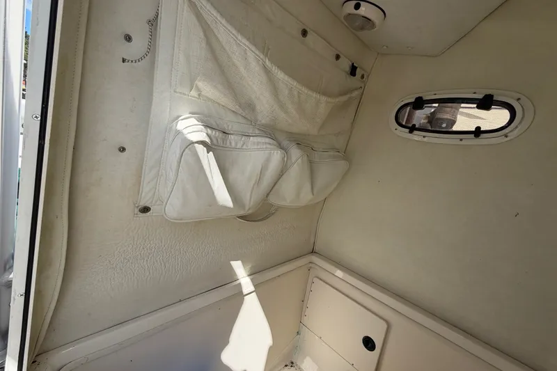 Slide: The Image of Interior cabin of a 1999 Boston Whaler 26 Outrage boat, featuring storage compartments. - 33
