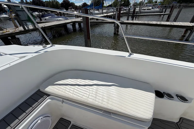 Slide: The Image of 1999 Boston Whaler 26 Outrage boat interior with cushioned seating by the dock. - 42