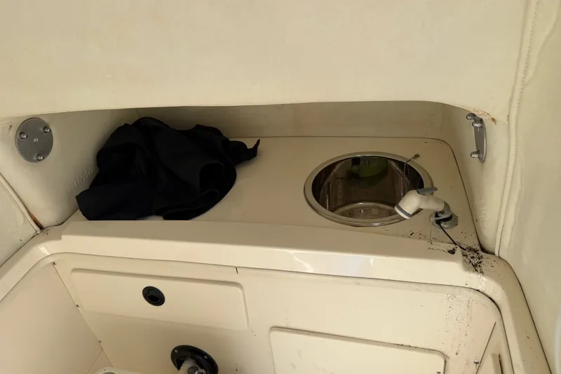 Slide: The Image of Interior of a 1999 Boston Whaler 26 Outrage boat with a sink and storage area. - 34
