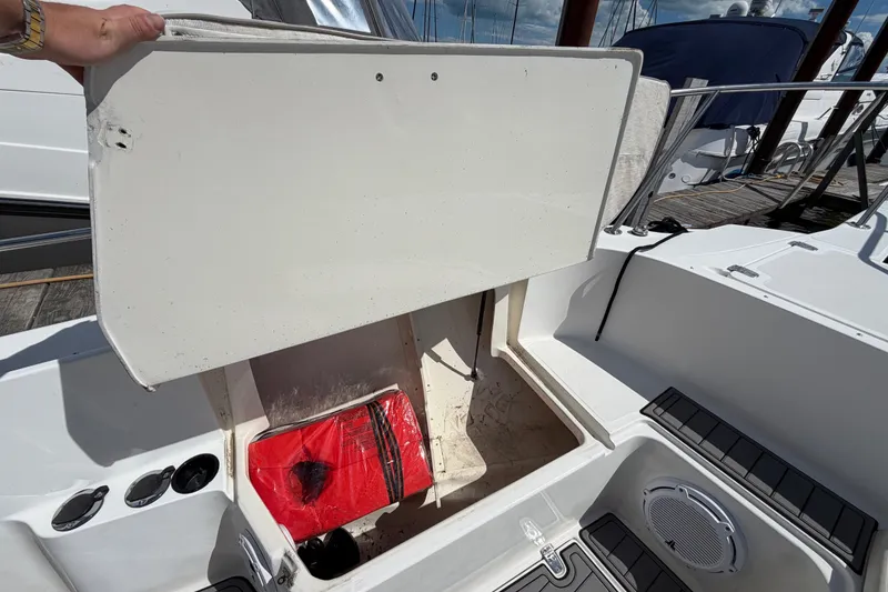 Slide: The Image of Open storage compartment on a 1999 Boston Whaler 26 Outrage boat, revealing a red bag. - 39