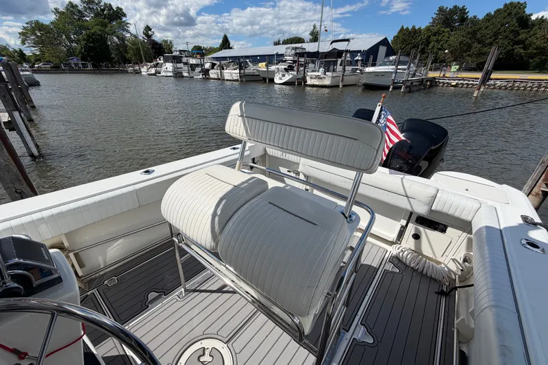 Slide: The Image of 1999 Boston Whaler 26 Outrage boat interior at marina, featuring seating and American flag. - 20