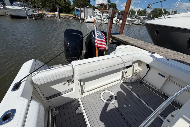 Slide: The Image of 1999 Boston Whaler 26 Outrage docked, featuring spacious seating and American flag. - 16
