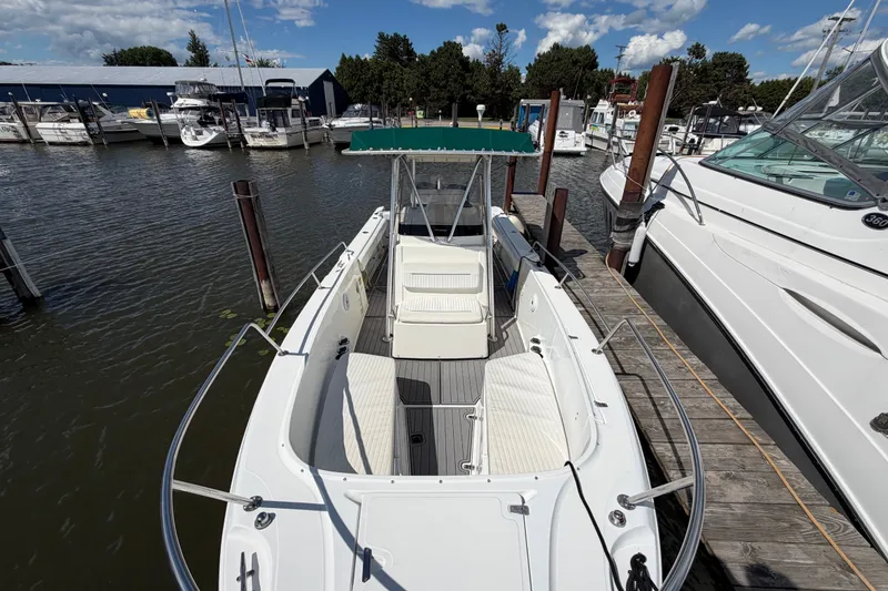 Slide: The Image of 1999 Boston Whaler 26 Outrage docked at marina, showcasing spacious deck and seating. - 46