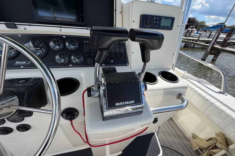 Slide: The Image of Control panel of a 1999 Boston Whaler 26 Outrage boat with steering wheel and throttle. - 26