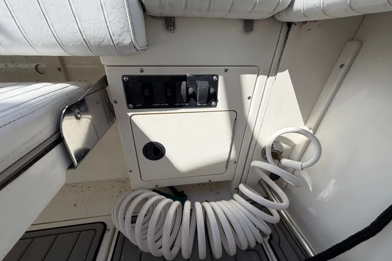 Slide: The Image of Control panel and coiled hose on a 1999 Boston Whaler 26 Outrage boat. - 14