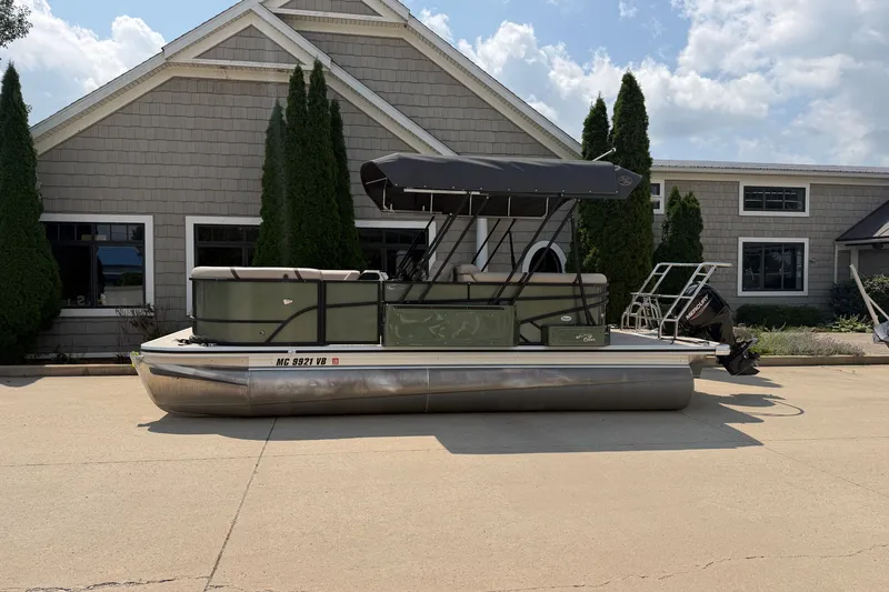 The Image of 2025 Crest Classic 200 pontoon boat parked outside a building under a clear sky. - 0