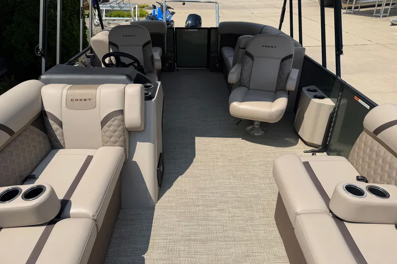 Slide: The Image of 2025 Crest Classic 200 pontoon boat interior with beige seating and cup holders. - 3