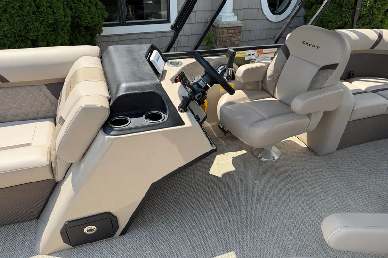 Slide: The Image of 2025 Crest Classic 200 boat interior with beige seating and steering console. - 6