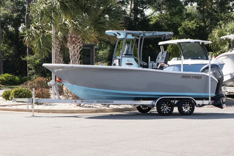 The Image of 2027 Sea Pro 222 Center Console boat on trailer, parked near palm trees. - 1